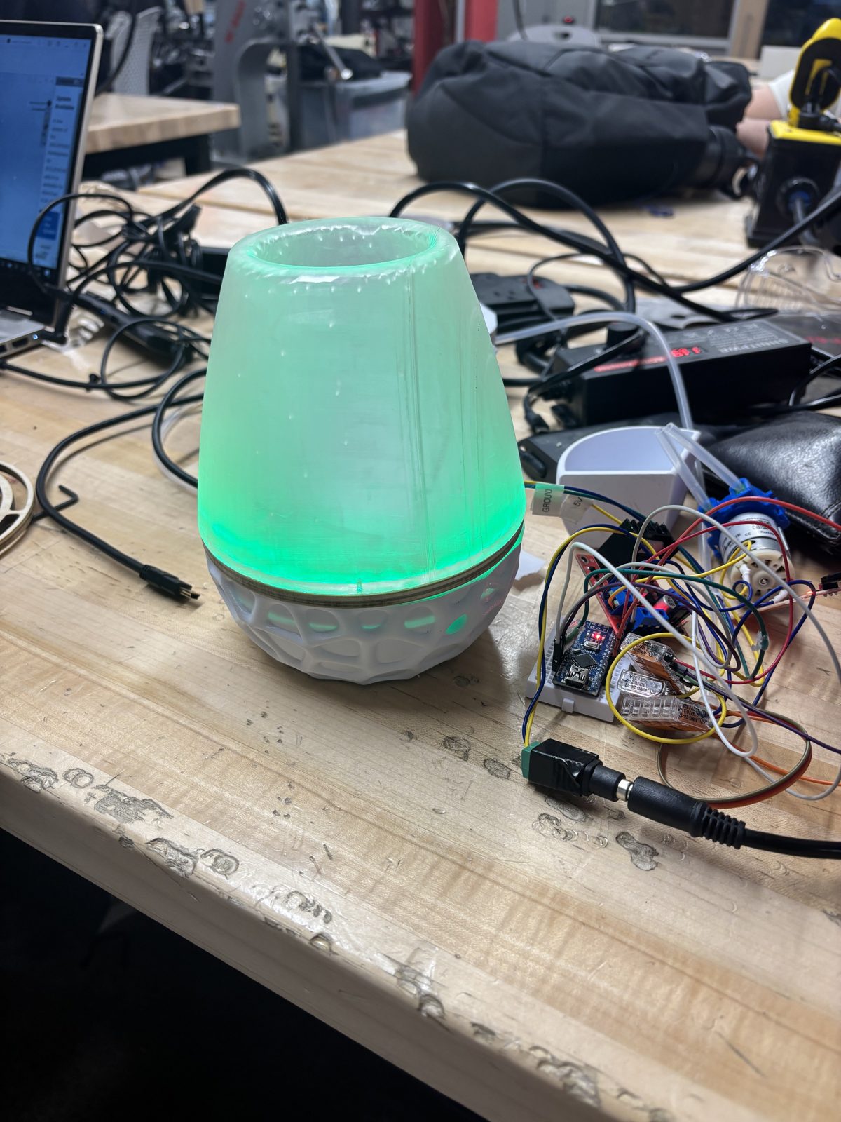 Lamp lit green next to the electronics on the workbench during testing