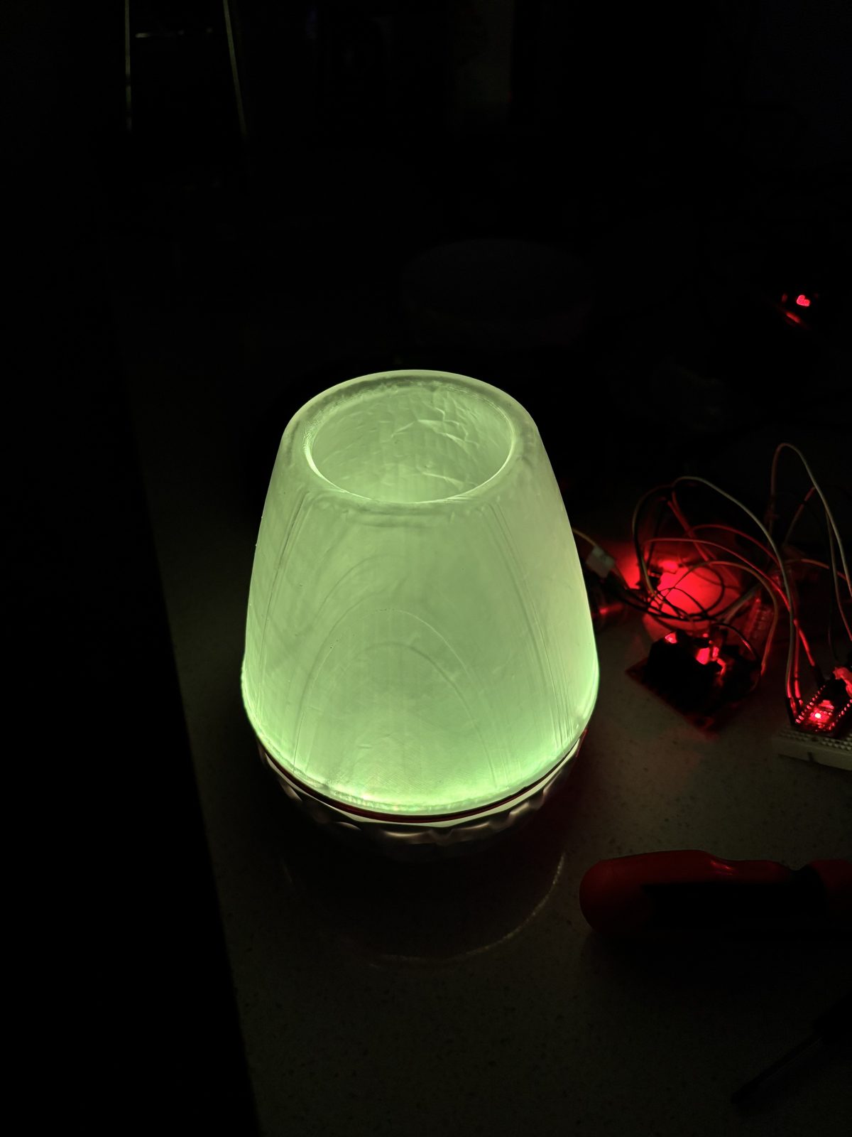 Lamp glowing green in a dark room