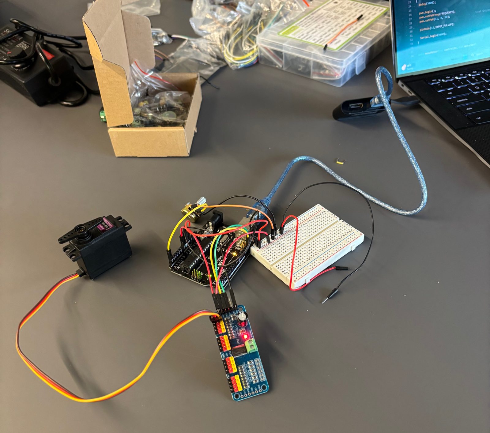 Breadboard and wiring setup on the desk, connected to the Arduino and servo driver board