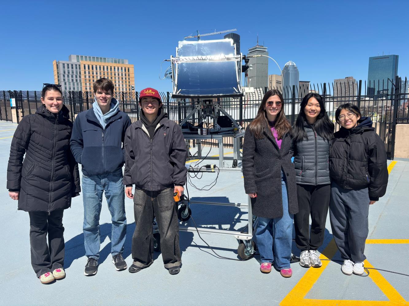 Team 19 standing with the solar trough prototype on the rooftop